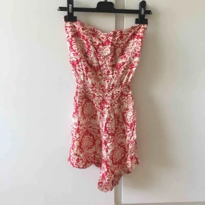  - Jumpsuit med knytning i ryggen. Öppen rygg och off-shoulder. 