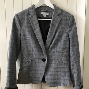  - Rutig kavaj i mycket bra skick!  Använd endast ett fåtal gånger, ny skick!   En knapp fram Två fickor, fortfarande oöppnade  Material 64% Polyester 33% Viscos 3% Elastan Foder: 100% Polyester  Upphämtas i centrala Uppsala Porto tillkommer vid frakt, 72kr