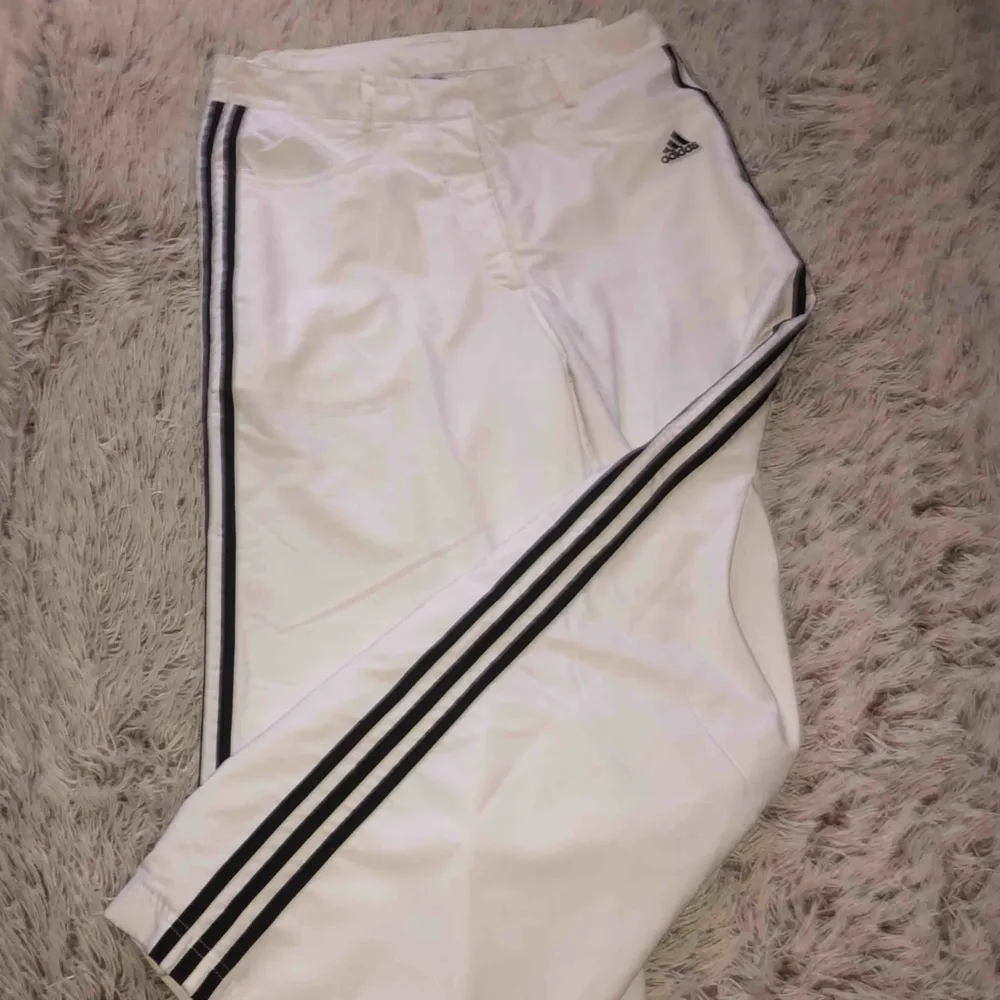 Ett par vita adidas butcut byxor, köpta på humana. Jeans & Byxor.