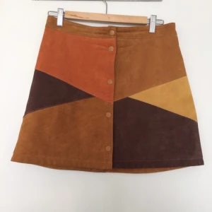  - Färgglad Monki kjol i läder. Superfint skick. Använd ett par gånger. Storlek 40 