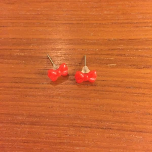  - Röda örhängen i form av rosetter. Ca 8mm stora.