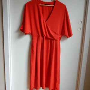  - Jättefin och färgstark klänning från Lindex. Använd 2 gånger. Band med hällor runt midjan som ger en otroligt fin form. 