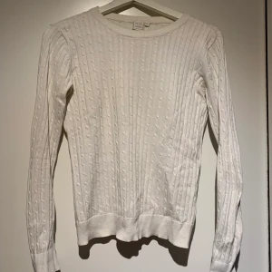 Vit kabelstickad tröja  - En vit kabelstickad, sitter fint och är skönt. I bra skick. 