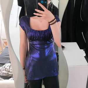 Jättefin tunika - En jätte söt tunika som skimrar i solljuset☀️ den skiftar lite i svart o lila och är jätte häftig! En jättefin urringning som passar bra till ett fin halsband och man kan knyta en jätte söt rosett där bak🌸 Köparen står för frakten🌸