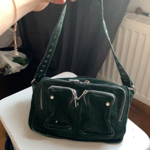 Grön Nunoo väska - Fick denna väska förra sommaren, använt en del men fortfarande i jättebra skick. Den är som ny. Den köptes för ca 1200-1400kr via deras hemsida och säljer den för 500kr. Kan skicka fler bilder om intresse finns. 