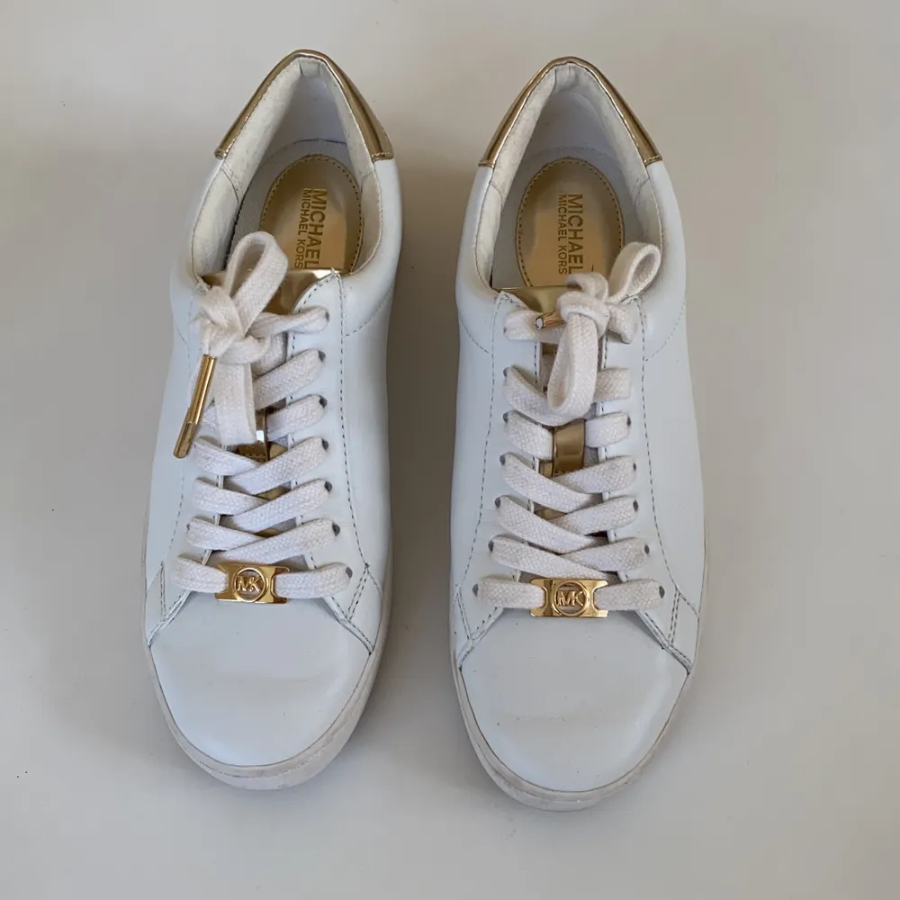Fina sneakers från Michael Kors. Använda endast 1 gång. Vita sneakers med guld detaljer. Skor.