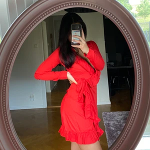 Omlottklänning med volanger - Röd somrig omlottklänning med volanger, från NAKD. Endast använd vid ett tillfälle så den är så gott som ny! Frakt tillkommer🍓