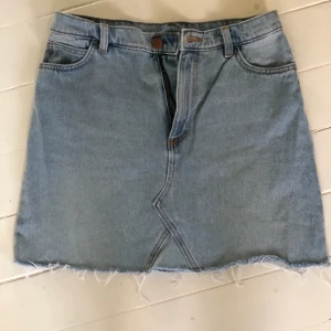 Jeanskjol från monki - Superskön jeanskjol från monki. Kort med lite fransigt nedtill!