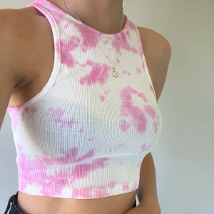 Tie-dye färgat linne/topp - Ett supersnyggt tie-dye färgat linne i en croppad modell. Har aldrig använt så det är nyskick. Frakt tillkommer på 22kr