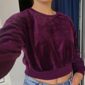 Lila croppad sweatshirt - En croppad lila tröja i fint sammetsmaterial från BikBok. fint skick! Säljer då den tyvärr blivit för liten, Pris går även att diskutera. 💜