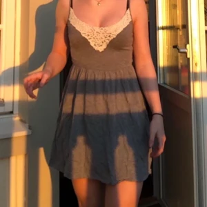 Grå sommar klänning  - Säljer denna jätte fina gråa klänningen med spetts vid halsen. Sitter som en smäck och kommer från Hollister (Köpare står för frakt)
