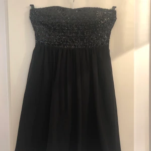 Partyklänning - Kort, svart, ärmlös paljettklänning. Använd en gång. I jättefint skick. Buda i kommentarsfältet. Ordinarie pris var 400kr. Köpare betalar eventuell frakt. 
