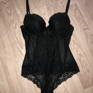Body i spets  - Svart body i spets med inbyggd bh, strl 38. Knappt använd! 