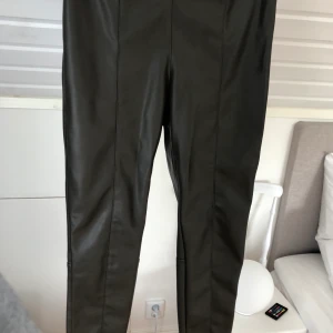 Mörkgrön skinbyxa storlek 40 - Super snygga mörkgröna skinnbyxor perfekta till hösten! Byxorna är i nyskick använd ca 3 gånger, jag är ca 174 cm och går till ankeln på mig. Storlek 40 (passar även 38)🤩