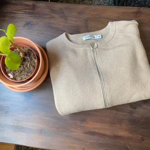 Tjocktröja - Fin beige tjocktröja med fin detalj från Carin Wester. Använd ett fåtal gånger. Mycket mysig!!🌿