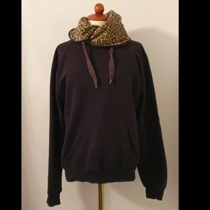 Svart hoodie med leopard mönster - Svart hoddie som har en mysig "krage" . Det är ingen luva men nästan som en halsduk🥰. Jätte skönt när det är kallt. Tröjan har mjuk insida.
