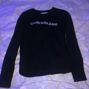 Calvin Klein sweatshirt  - En mörkblå Calvin Klein sweatshirt med vit text. Har använt lite men ändå i bra skick, 8/10. Den är i strl XS/S skulle jag säga. Super fin och lagom tjockt material.  