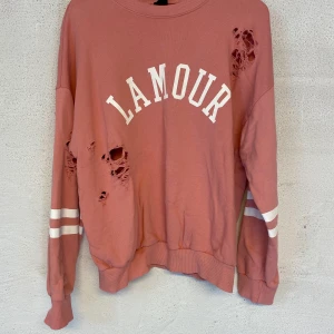 Sweatshirt från Gina Tricot  - Rosa sweatshirt ifrån Gina Tricot men slitnings detaljer. Tröjan är i mycket fint skick och använd ett fåtal gånger. Säljer för 80kr och är i storlek M. Köparen står för frakten.