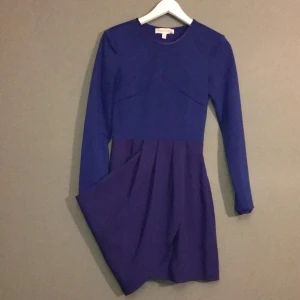 findersKeepers - Blå elegant kort klänning, figursydd med volang. Framhäver figuren med en tight modell. Köpare står för frakt!