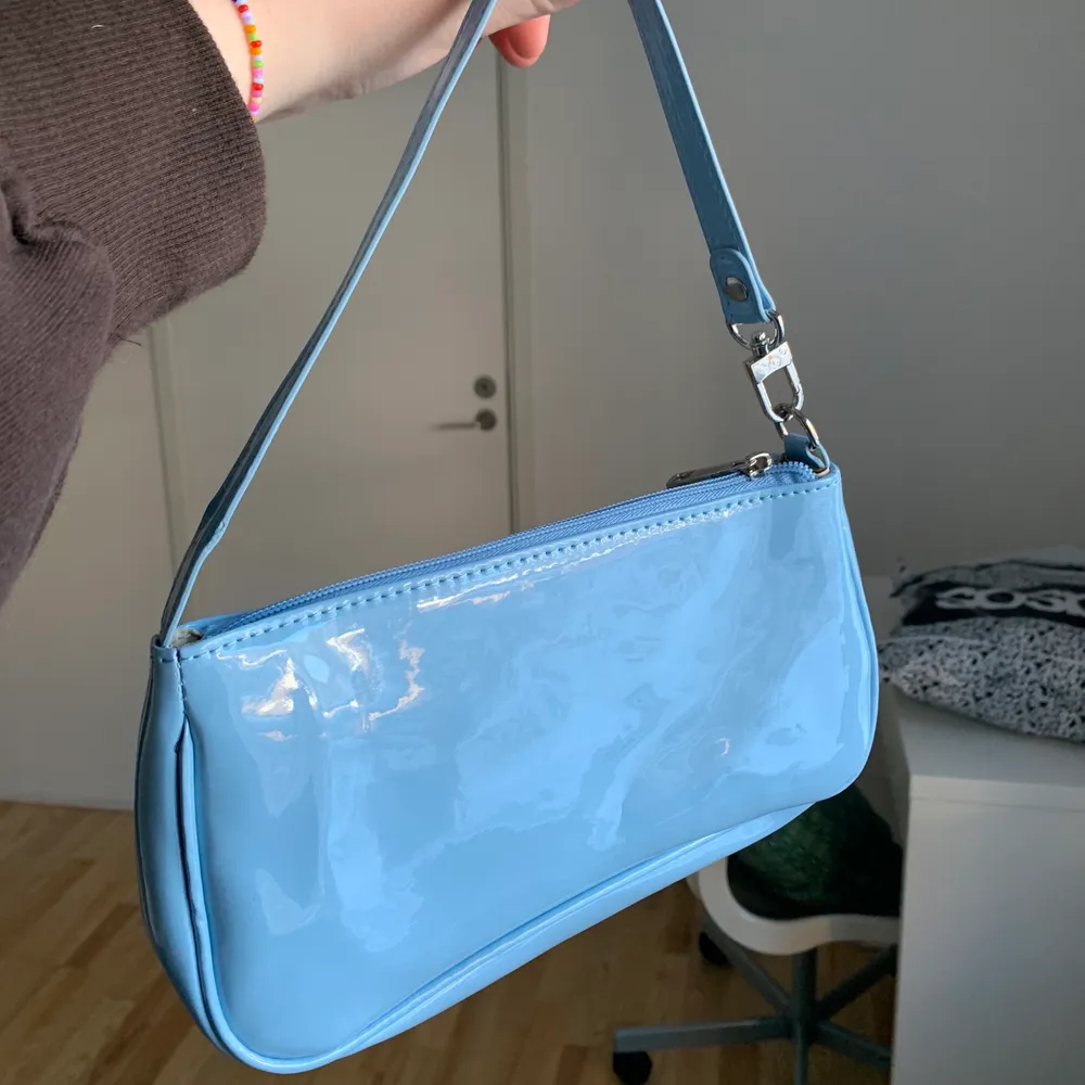 En blå väska i lackat material som jag köpt här på Plick! Var för liten för min smak men hoppas den kan glädja någon annan 💖 Frakten går på 57:-. Väskor.