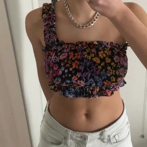 Blommig topp one shoulder - Säljer en blommig topp med one shoulder modell. Köpt i Nice.