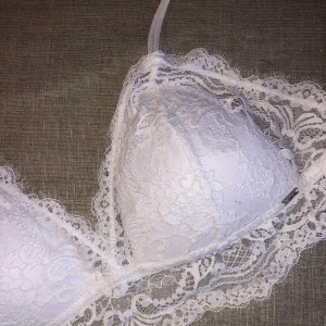 Bralette med spets - Så fin bralette i vit spets från Ella M (Lindex). Använd endast en/två gånger då den tyvärr är för stor, vilket gör att den är som ny. Storleken är L på lappen men passar även M.  Skicka ett DM eller skriv i kommentarsfältet 🌸