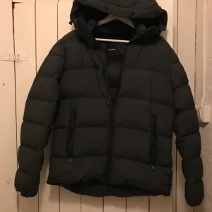 Dunjacka J.Lindeberg - En snygg varm dunjacka som endast är använd en vinter färgen är gråsvart.