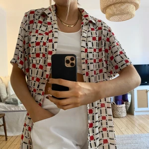 Vintage 70-tal kortärmad skjorta stl XL - Riktig snygg och cool blus/skjorta köpt på second hand. Det var axelvaddar men dom har jag klippt av. Populärt 70-talsmönster! Fint skick och snygg att knyta eller ha öppen.