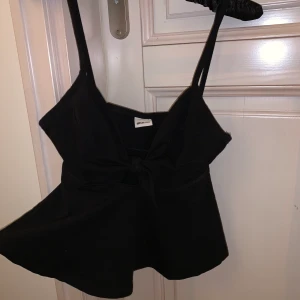 Svart topp - Gullig svart topp med knytning vid brösten. Den är i stretchigt material så den passar även på den som har storlek M. Köparen står för frakt🥰
