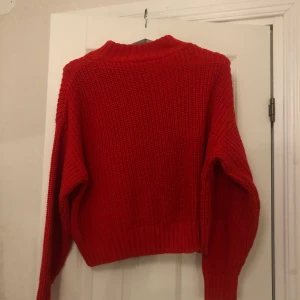 Stickad tröja - Röd stickad tröja med liten polokrage. Har en liten fettfläcka på bröstet, men inget man lägge märke till💕