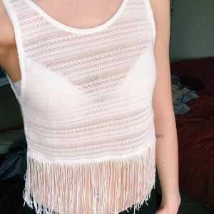  - Vit småvirkad topp i lite bohemisk anda med fransar nedtill. Sparsamt använd. Köparen betalar frakt. 