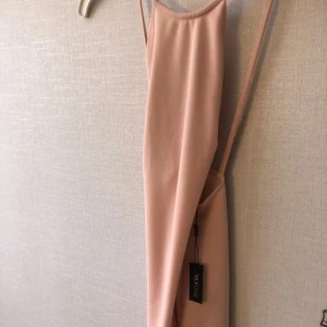  - Helt oanvänd klänning. Väldigt fin färg och ryggen är väldigt fin på 