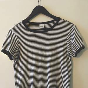Fin, simpel svart och vit-randig T-shirt som piffar upp en vanlig, bekväm outfit.  