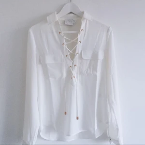  - Vit blus med snörning framtill. Väldigt fint skick. Storlek S och passar mig som vanligtvis har S och är 176 cm lång. Frakt tillkommer om plagget ska skickas 😄