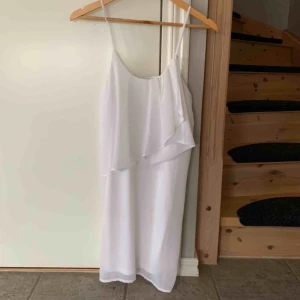  - Vit klänning perfekt till student eller skolavslutning. Använd 1 gång. Enkel tunn klänning med en sned volang fram. Hör av dig om du undrar något:) 