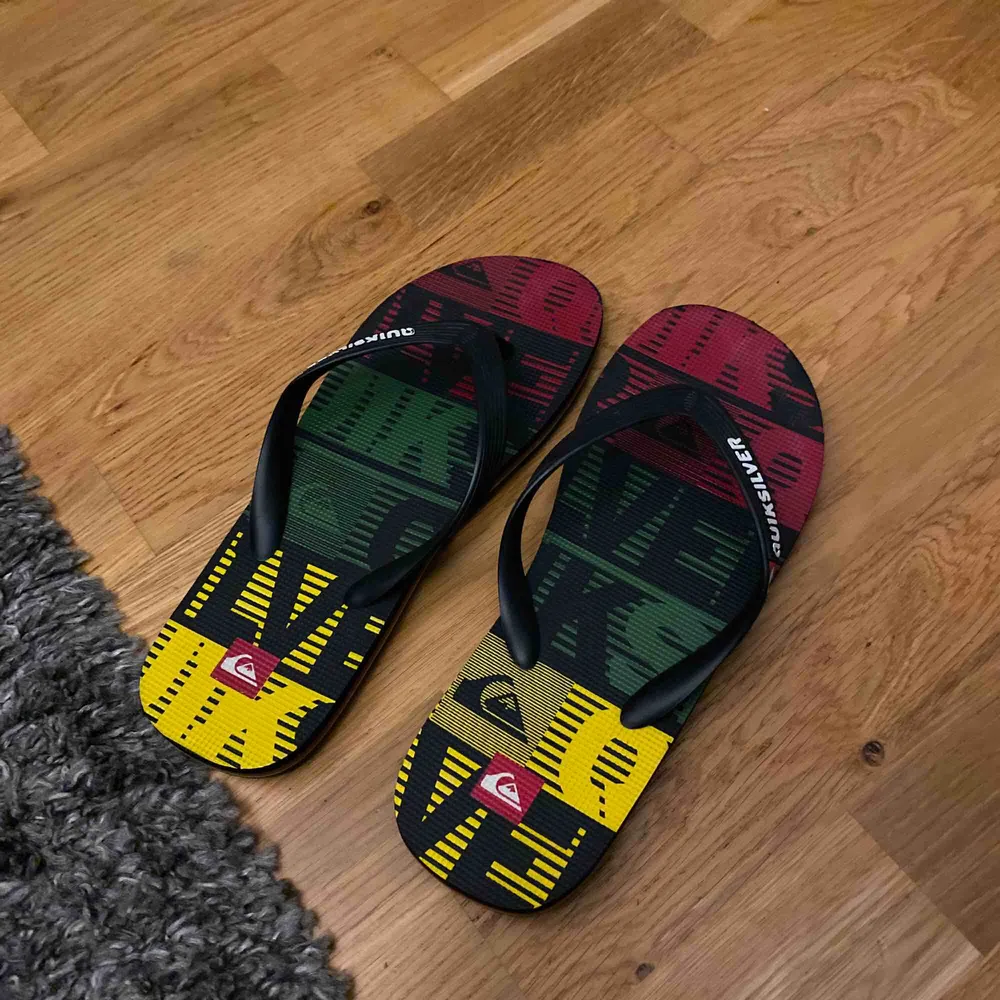 Snygga Quicksilver flip-flops i röd, grön och gul i stl. 42 Perfekt som strandskor  Bra skick (knappt använda). Skor.