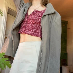 Pudergrön kostymjacka med krage - Fin thriftad kostymjacka i lugn gröngrå färg. Uttagna axelvaddar men med tydliga axlar ändå.