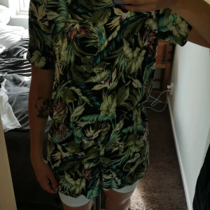 Byxdress - Byxdress i skönt tyg. Luftigt i coolt blommigt mönster. Grön. Knäppe i nacken. 