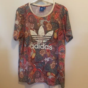 Adidas tshirt - Säljer en ball o färgglad Adidas tshirt, fint skick. 100kr , köparen står för frakt. Strl 14.