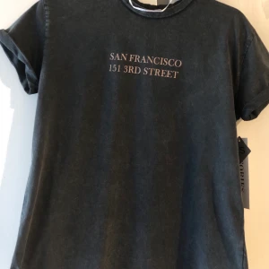 T shirt  - Grå t-shirt med text fram. Helt ny och oanvänd med alla lappar kvar. Säljes då den ej kommer komma till användning. Storlek XS men passar S också.