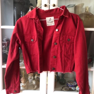 Röd croppad jeansjacka från Pull & Bear - Riktigt snygg röd croppad jeansjacka i toppskick från Pull & Bear. Storleken är XS men den är väldigt oversized så passar perfekt på mig som vanligtvis har S/M i jackor. Snyggt oversized! Säljs pga flyttrensning. 🥰 Buda från 200kr i kommentarerna. 