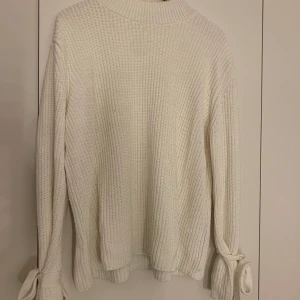 Vit stickat tröja - En as skön stickad tröja med rosetter vid handlederna, frakten hamnar på 50kr och budgivning pågår i en vecka ❣️❣️