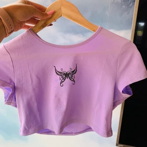 Lila Fjäril croptop - Sjukt söt croppad top med fjärilsmotiv i lila färg. Köpt här på Plick. Väldigt snygg och ovanlig. Priset är inklusive frakt.
