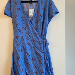 Blommig klänning - Skit snygg blommig klänning som aldrig kommit till användning! Prislapp kvar. Liten i storleken. Frakt tillkommer