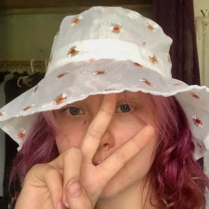 unik buckethat - Unik buckethat från shein med små söta prästkragar (?) på som tyvärr aldrig kommit till användning. Som ny och går att spänna åt (se bild 3). Kan mötas upp i Sthlm/Vxo annars står köpare för frakt♥️