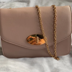 Liten handväska - Rosa/beige väska med guld detaljer från Glitter. Använt dem ett par gånger men är i bra skick.