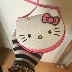 Hello Kitty handväska - 14 cm bred 11 cm lång och 70 cm axel band. Precis som ny, ej använd. Köp nu ☂️