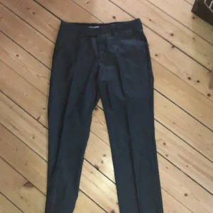 Grå Kostymbyxor - Gråa kostymbyxor köpta secondhand. Lågmidjade som kommer va inne i vår. Säljer för de är lite små på mig. Skulle säga att de passar en S. Frakt tillkommer