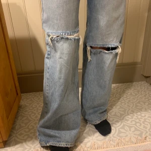 Vida jeans med slitningar  - Säljer dessa moderna jeans från pull and bear! Hon på bilden är 1.60 men passar även lite längre. Sitter bra på. Fint material och är i gott skick. Använda en gång. 220 eller buda till senast 22a.