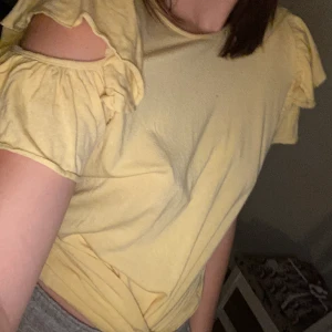 Gul t-shirt - Gul t-shirt med volanger och hål vid axlarna, super fin. Jag står för frakten!😊 OBS köp 3 plagg (50kr) betala 100kr PLUS jag betalar frakten!😍❤️😊